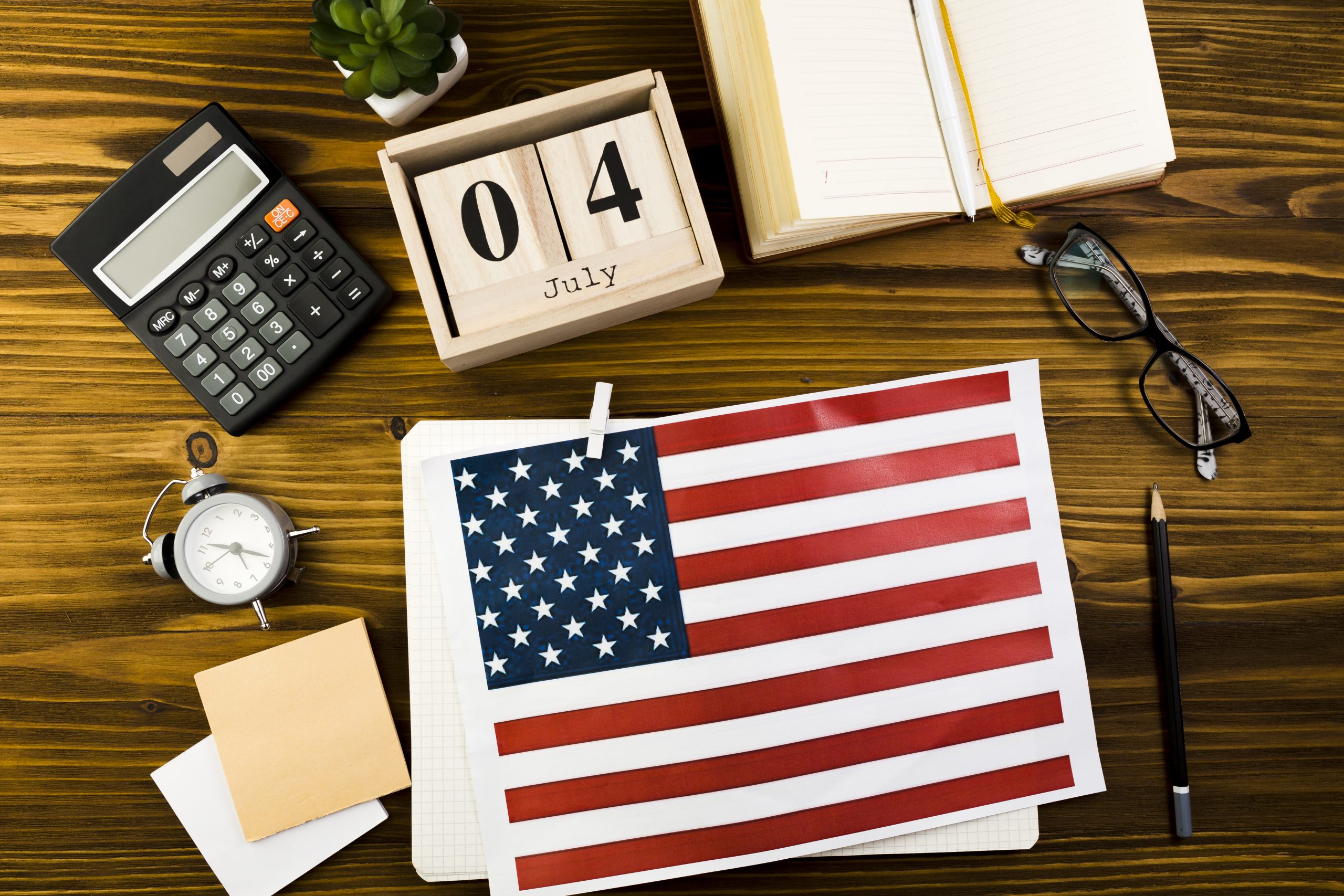bandeira dos estados unidos em uma mesa com calendário e calculadora